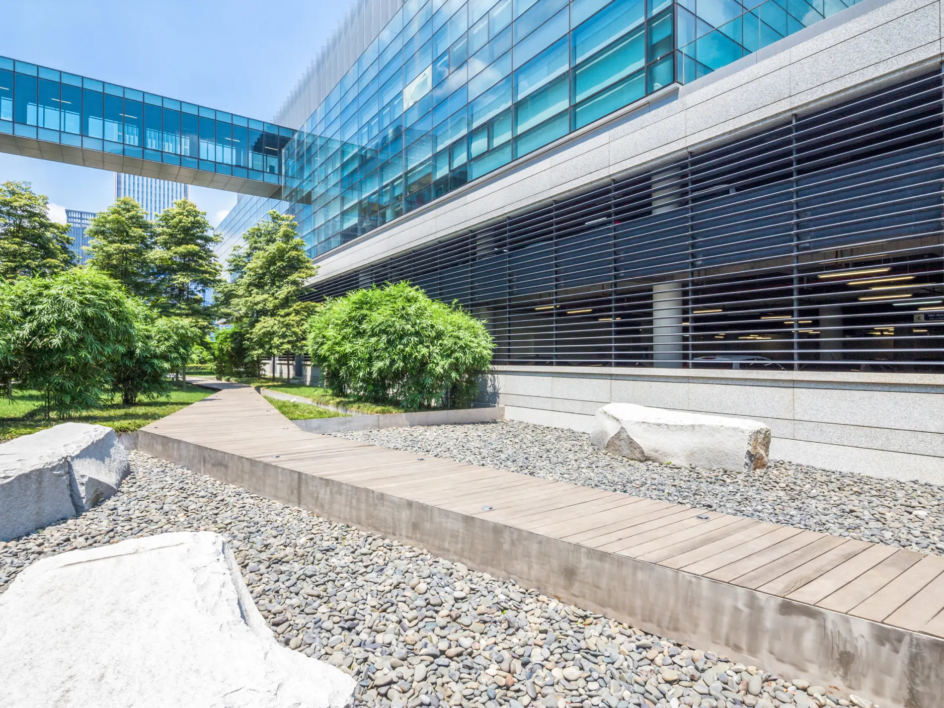 Real estate and financial services building exterior with beautiful landscaping and a walking bridge.