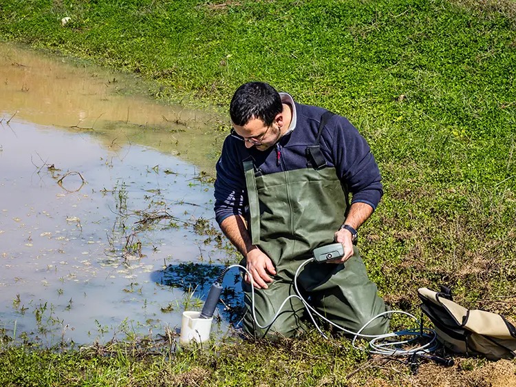 Scientist collecting water samples as part of a natural resource evaluation to determine eligibility for site development