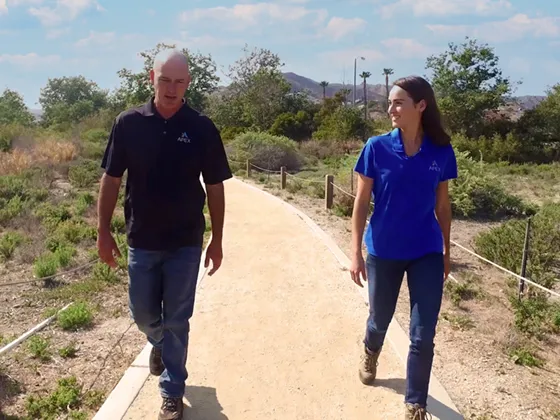 Apex employees walking and talking on a project site where they were contracted to provide environmental consulting.